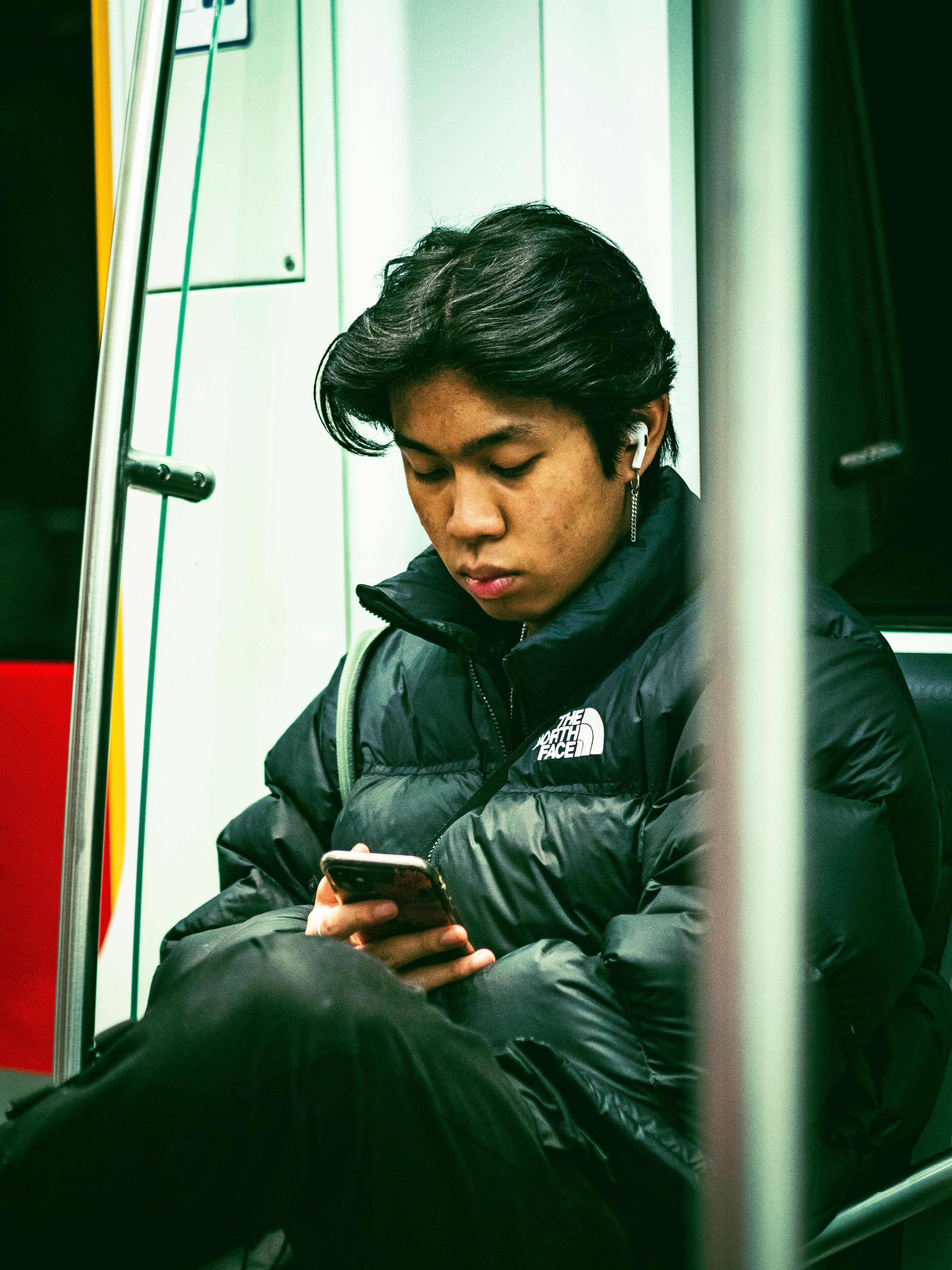 Jonge man met oortjes luistert op de trein naar audio